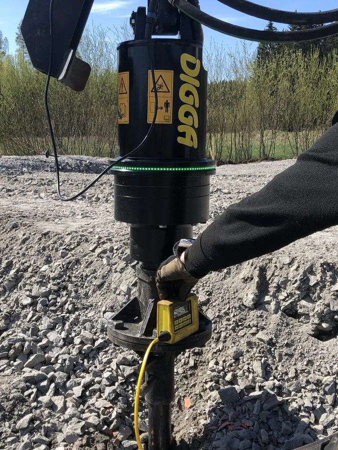 Gros plan de la tête Digga installant des pieux vissés pour les fondations de serre à Cassandras Tradgard, Porvoo