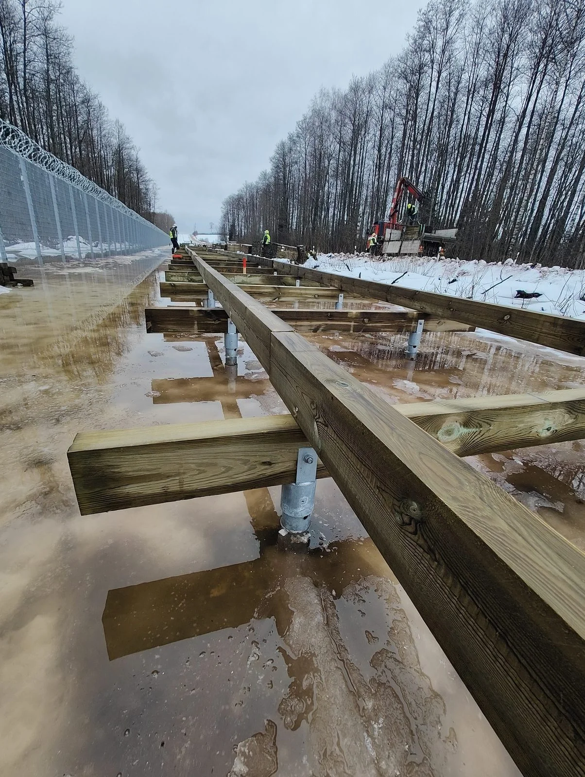 Ossature de passerelle en bois montee sur consoles en U de pieux vissés